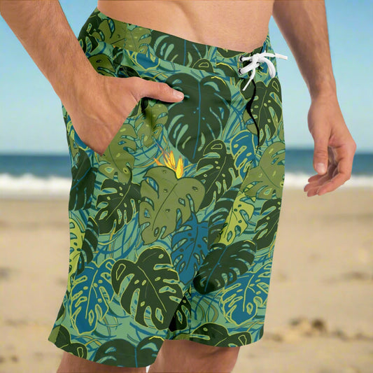 Mens board shorts with tropical monstera leaves and bird of paradise flowers