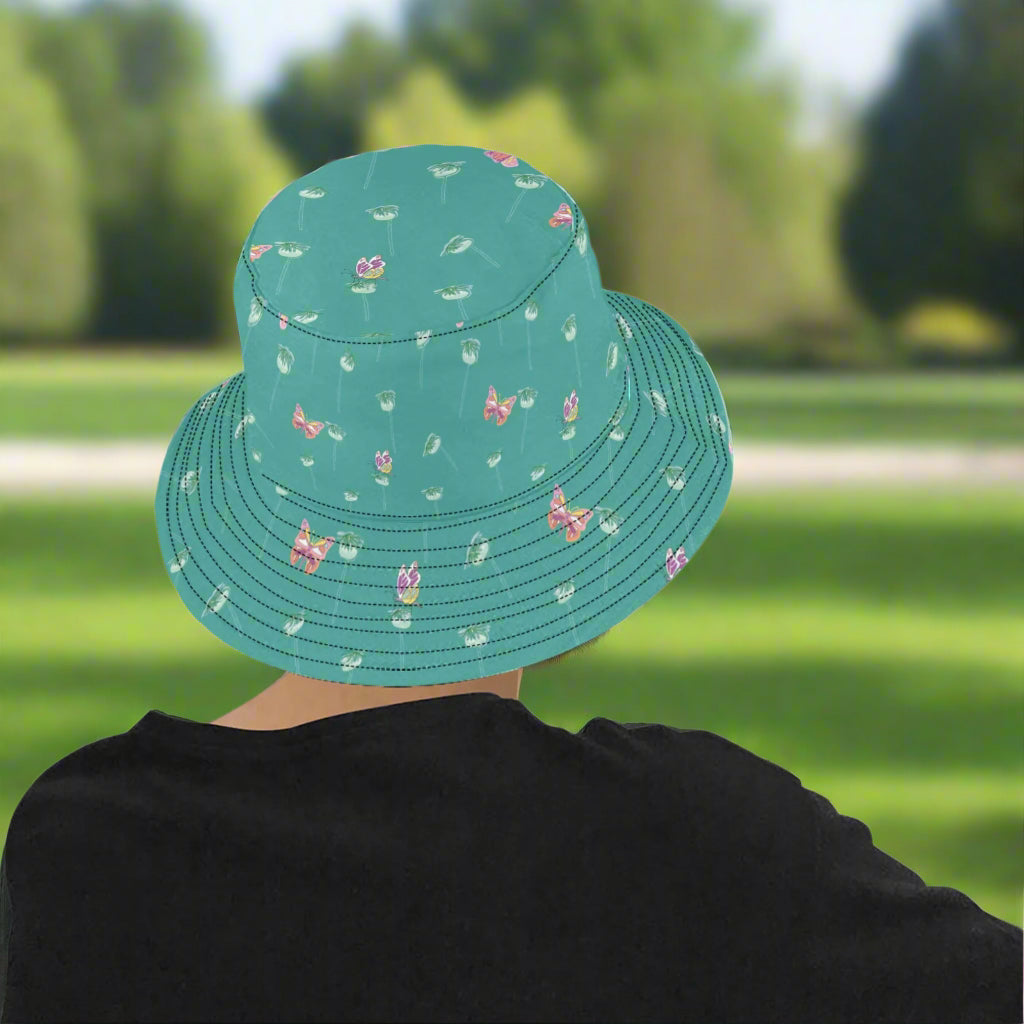 model wearing butterflies_on_seedpods_bucket hat sitting_on_park_bench