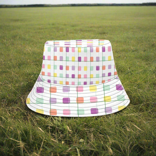 Bucket hat with spring flower squares design sitting on the grass in a field